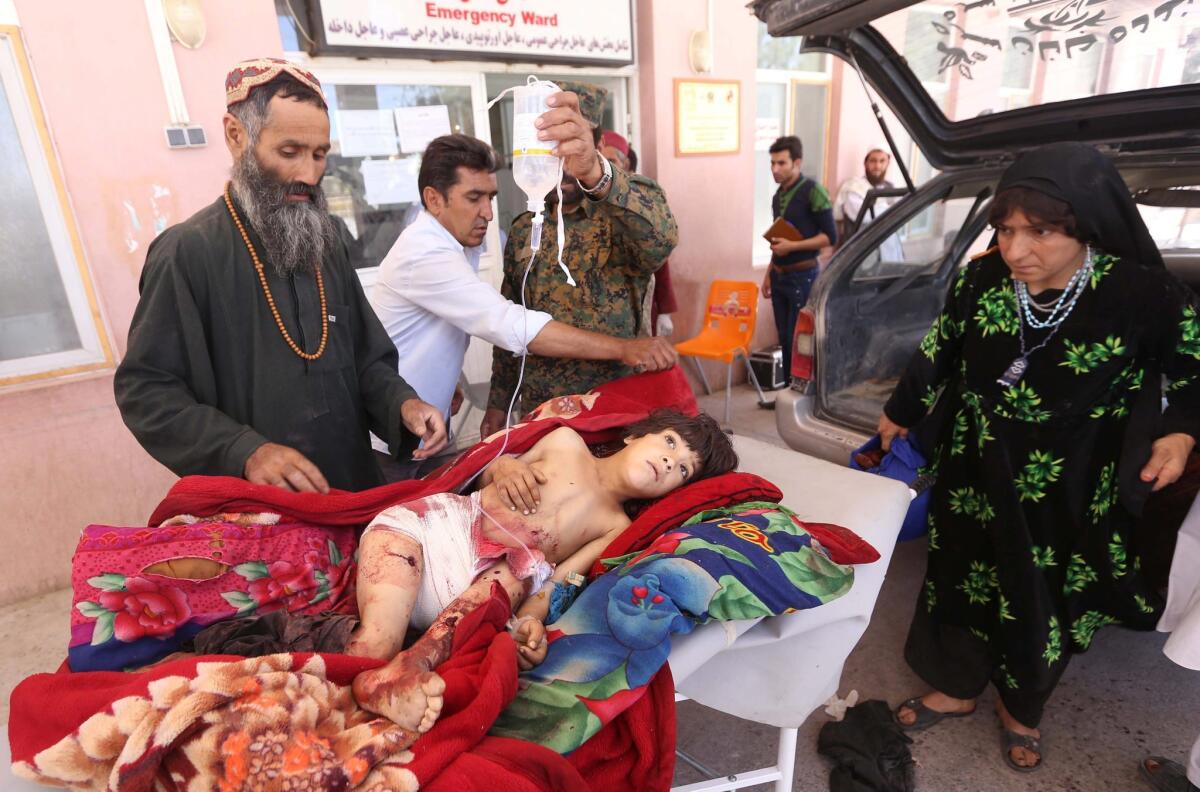 A girl wounded when a bomb exploded at a playground arrives at a hospital in Afghanistan's Herat province on Thursday.