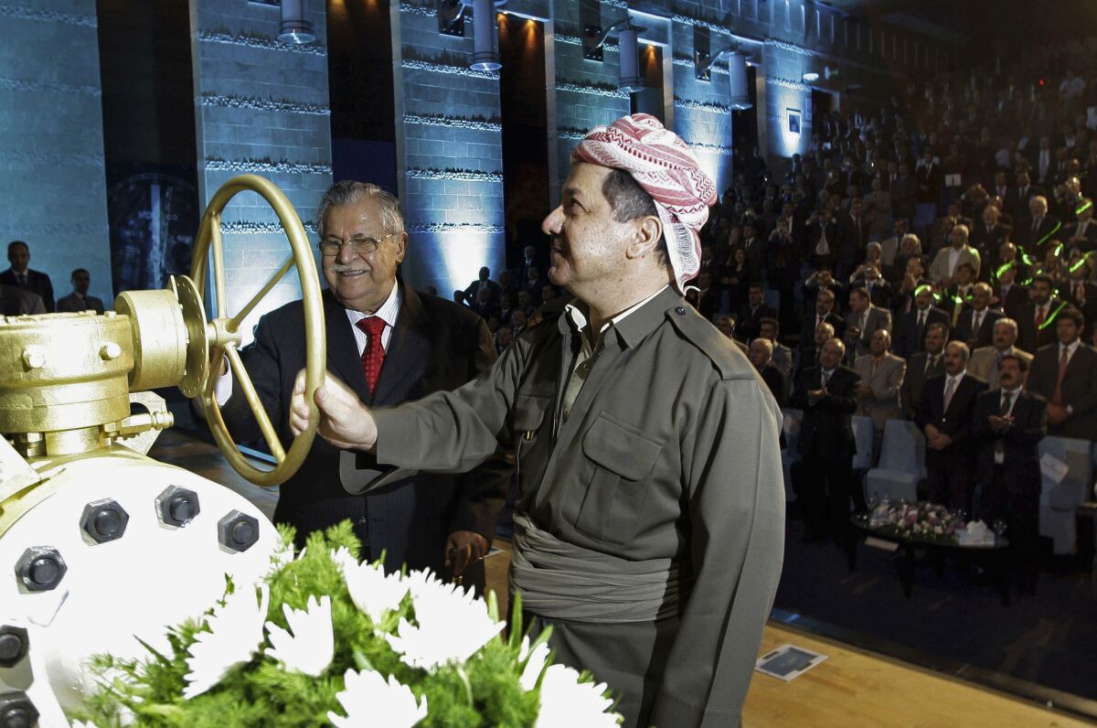 FILE - Then Kurdish President Massud Barzani, right, and then Iraqi President Jalal Talabani open a ceremonial valve during an event to celebrate the start of oil exports from the autonomous region of Kurdistan, in the northern Kurdish city of Irbil, June 1, 2009. A surprise ruling by Iraq's Supreme Court cast doubt on the legal foundations of the independent oil policy of Iraq's Kurdish-run region and threatened to drive a political wedge between the two governments, officials warned Wednesday, Feb. 16, 2022. The ruling on Tuesday called into question the future of the region's oil contracts, exports and revenues. (AP Photo/Safin Hamed, Pool, File)