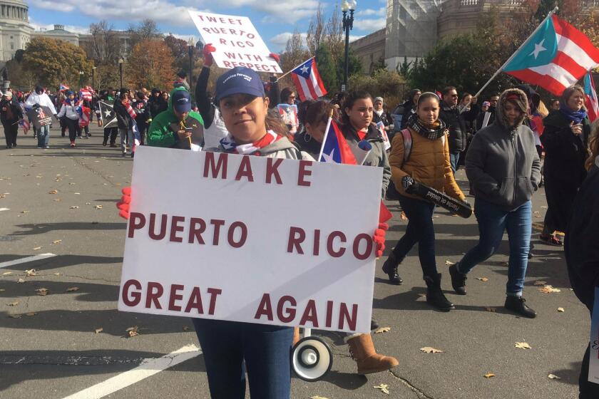 People carry signs during a protest for Puerto Rico on November 19, 2017 in Washington,DC. Puerto Ricans protested in Washington on Sunday in solidarity with their hurricane-hit island, criticizing the US response to the storm and calling for changes to be made. Hurricane Maria slammed into Puerto Rico in September, ravaging its infrastructure. Some 50 percent of its population of 3.4 million people is still without electricity more than two months later.Demonstrators gathered at the US Capitol building, with Puerto Rican flags and signs that read "Fight for Puerto Rico," then marched toward the Lincoln Memorial at the other end of the National Mall. / AFP PHOTO / W.G. DunlopW.G. DUNLOP/AFP/Getty Images ** OUTS - ELSENT, FPG, CM - OUTS * NM, PH, VA if sourced by CT, LA or MoD **