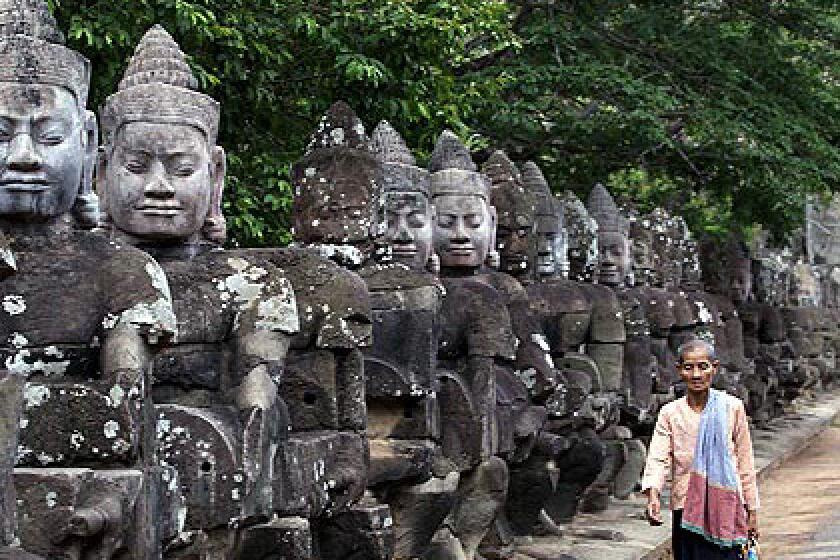 Statues line a roadway in the Angkor temple complex in Cambodia.