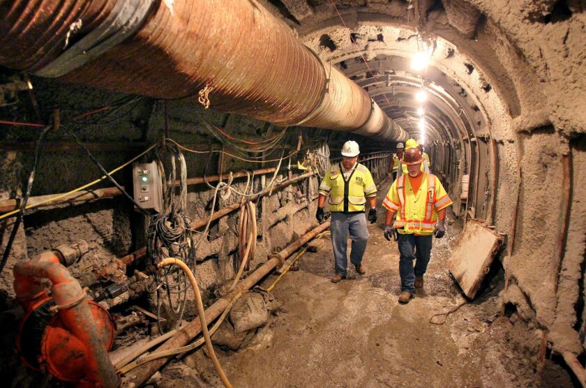 Inside the 1,700-foot-long Macario Tunnel, part of the 10-mile pipeline that will carry water from Carlsbad's desalination plant to San Marcos where it will connect to the S.D. County Water Authority system. Leading a group of workers and visitors are tunnel project mangers Matt Roberts, at left, and Trey Martin, at right.