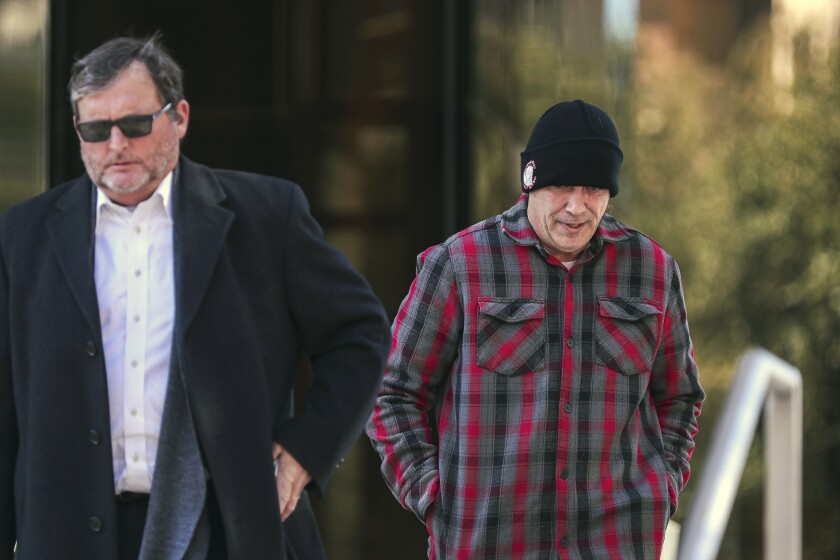 Chad Stark, right, follows his attorney Horatio Aldredge out of the United States Federal Courthouse after a short hearing Friday, Jan. 21, 2022 in Austin, Texas. The U.S. Justice Department said Friday that Stark, a Texas man has been arrested on charges of posting threatening messages on Craigslist about killing government officials in Georgia following the 2020 election. (Aaron E. Martinez/Austin American-Statesman via AP)