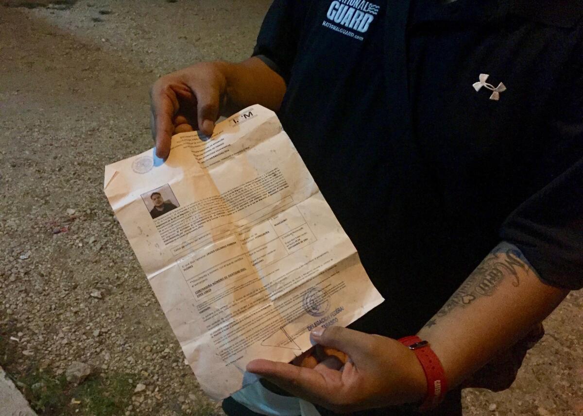 Javier Eduardo Ferrera, 23, who was deported to Honduras from North Carolina in September, shows off a document giving him the right to temporarily stay in Mexico while his request for a humanitarian visa is processed.