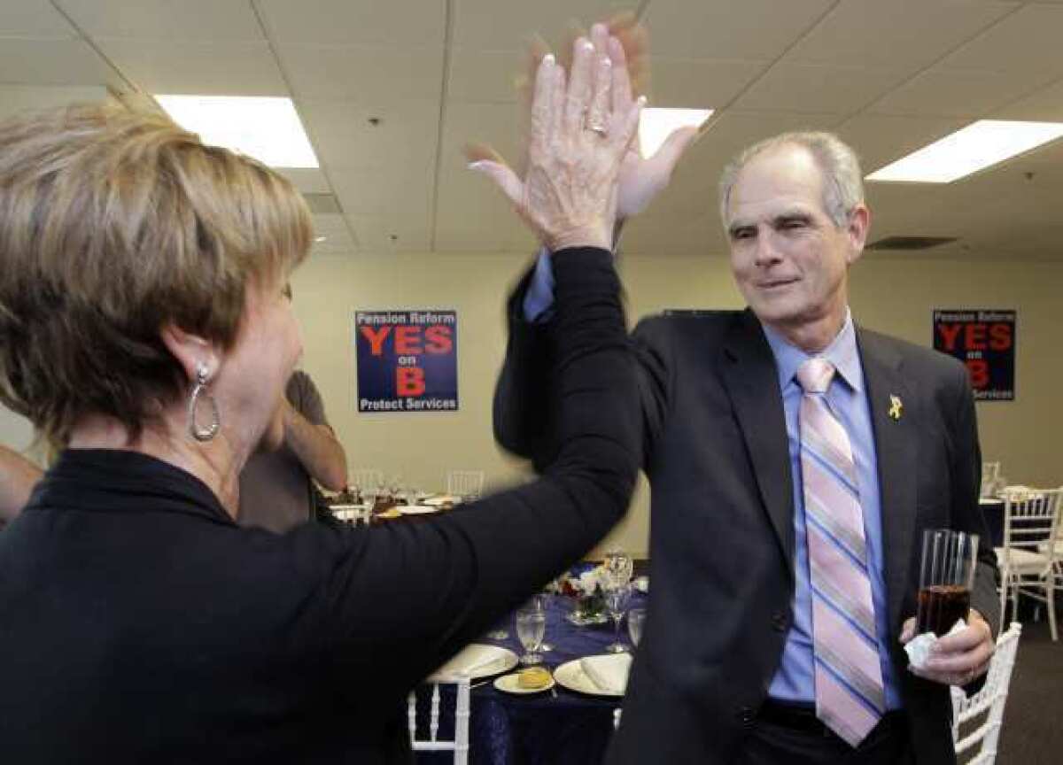 San Jose Mayor Chuck Reed, right, gives a high five as he arrives at a campaign party in San Jose in June 2012. His city approved a plan to roll back retirement benefits for public employees, but his statewide effort has hit a legal speed bump.