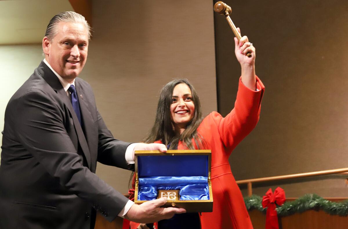 Gracey Van Der Mark raises a gavel given to her Tuesday by outgoing Huntington Beach Mayor Tony Strickland.