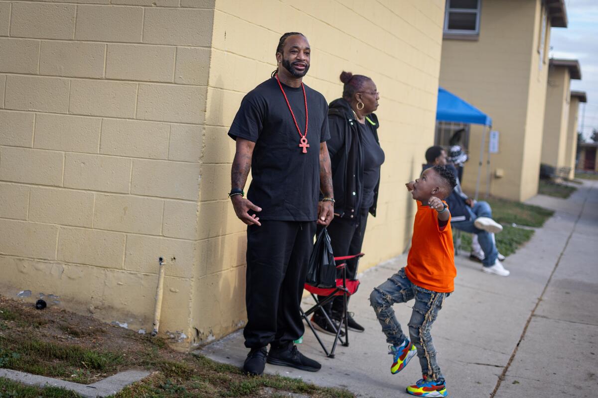 Tiny B. and his godson Ckaelyn Wells, 7,  wait for Top Dawg Entertainment's annual toy drive and concert to start Tuesday at the Nickerson Gardens housing project  in Los Angeles.