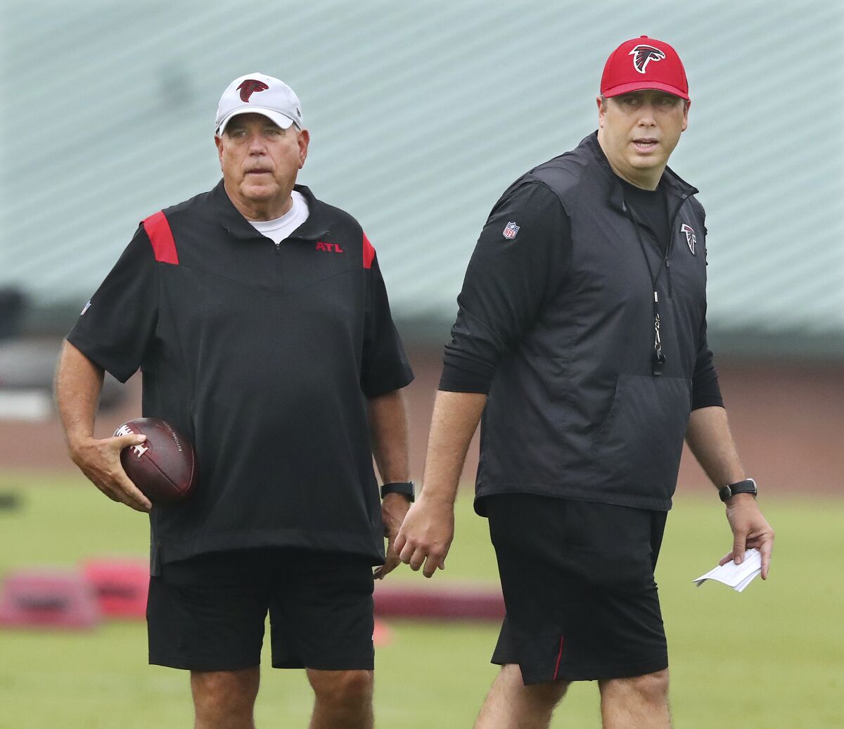 FILE - Atlanta Falcons defensive coordinator Dean Pees, left, and head coach Arthur Smith, right, watch during the NFL football team's training camp on July 30, 2021, in Flowery Branch, Ga. Pees, in his second-year defensive coordinator, is determined to make improvements after only two teams allowed more points than Atlanta in 2021. (Curtis Compton/Atlanta Journal-Constitution via AP)