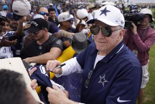 Dallas Cowboys owner Jerry Jones signs autographs during the NFL football team's training camp