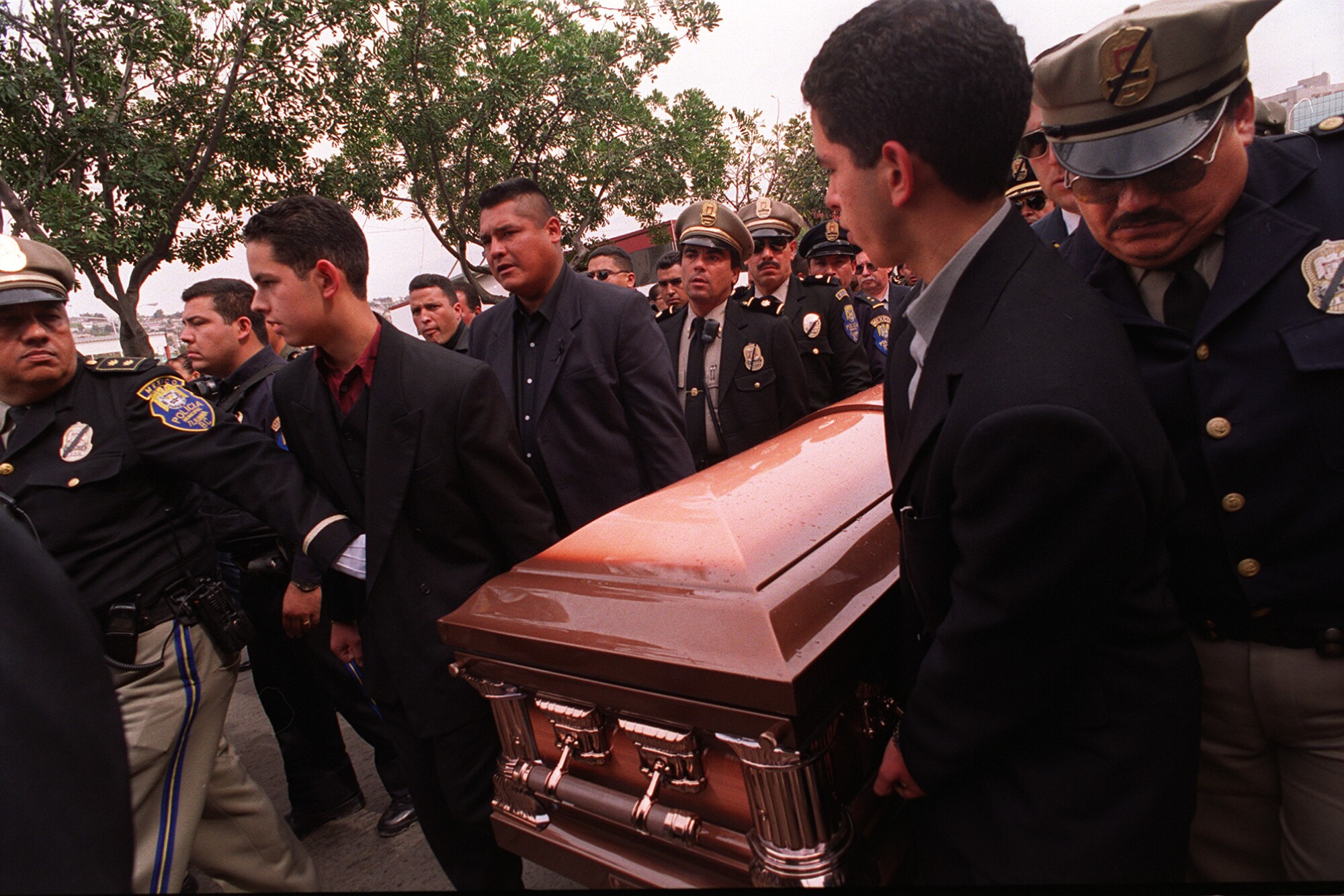 Los hijos del asesinado jefe de policía de Tijuana, Alfredo de la Torre, ayudan a llevar el féretro