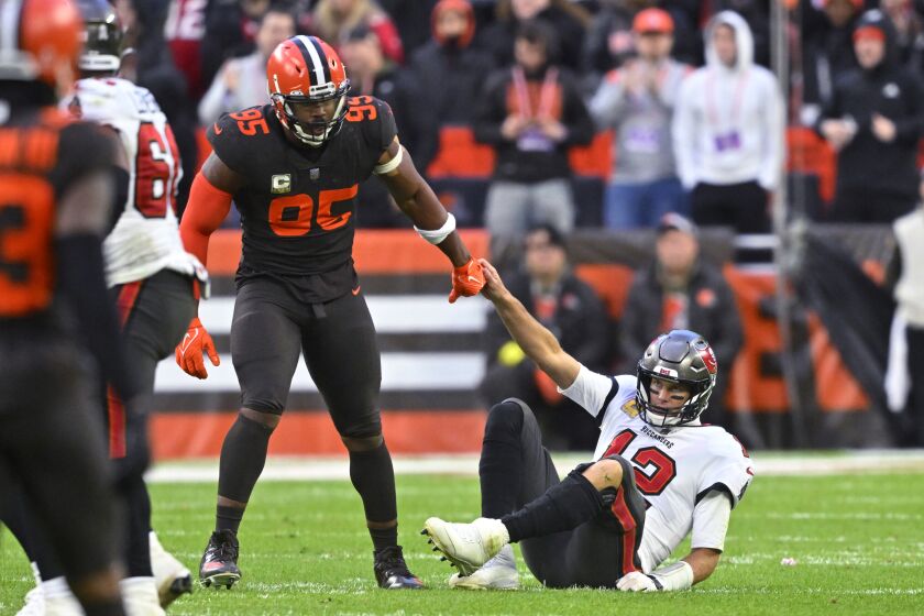 Cleveland Browns defensive end Myles Garrett (95) helps up Tampa Bay Buccaneers quarterback Tom Brady (12) after sacking him during the second half of an NFL football game in Cleveland, Sunday, Nov. 27, 2022. The Browns won 23-17. (AP Photo/David Richard)