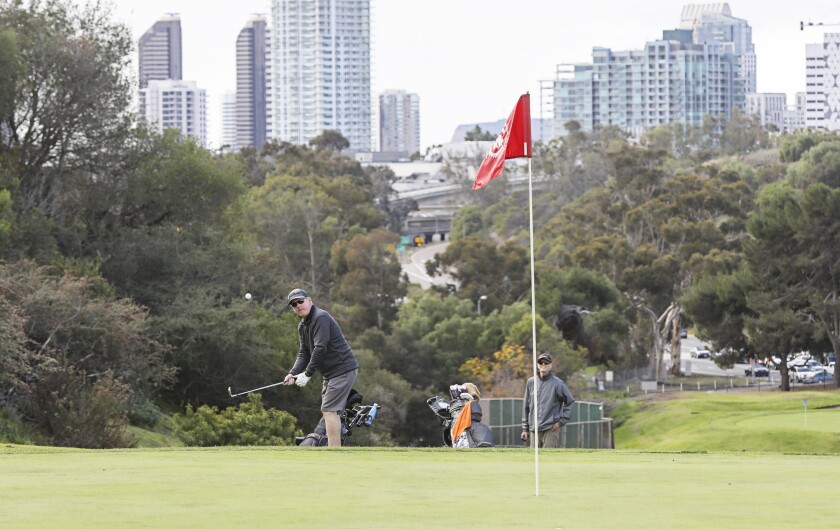 With city views, golfer Jim Kelly chips on to the 18th hole at Balboa Park Golf Course Tuesday, Dec. 28, 2021 in San Diego. 