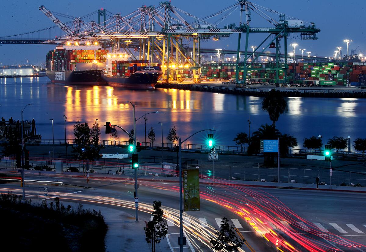 Container ships discharge cargo in the Port of Los Angeles as traffic streams nearby in San Pedro in 2021.