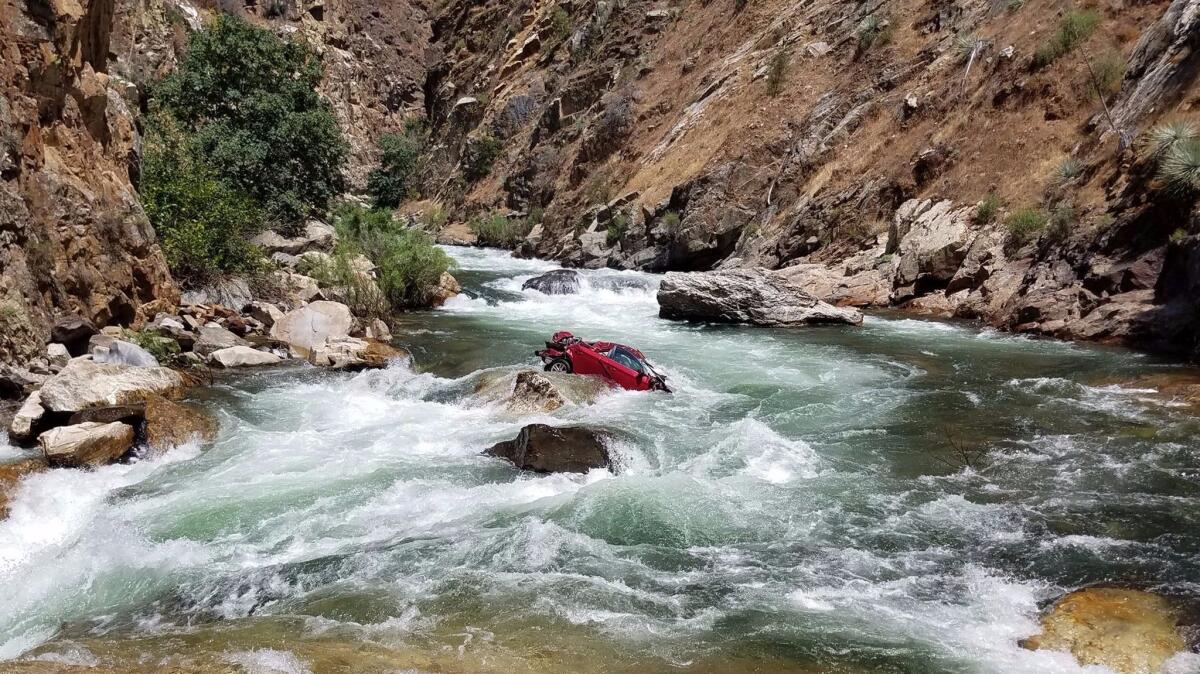 A photo provided by the Fresno Country Sheriff's Office shows a car in the middle of a portion of the Kings River that is believed to house the bodies of two Thai nationals.