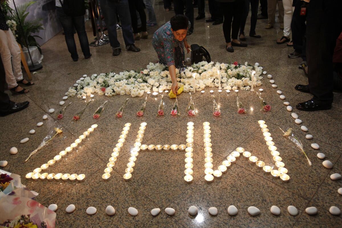 Un miembro de la tripulación de Malaysia Airlines deposita una vela junto a velas que forman las MH17 tras un servicio multireligioso por las víctimas del avión de la compañía derribado en Ucrania, en Kelana Jaya, cerca de Kuala Lumpur, Malasia. (Foto AP /Lai Seng Sin, archivo)