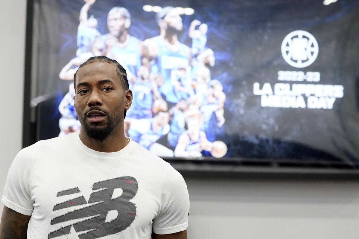 Clippers forward Kawhi Leonard walks up to field interviews during media day.