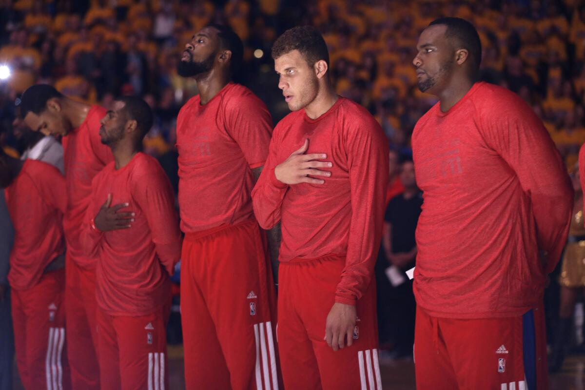 Clippers players listen to the national anthem, wearing their warmup jerseys inside-out so the Clippers' team name could not be seen, before Game 4 Sunday.