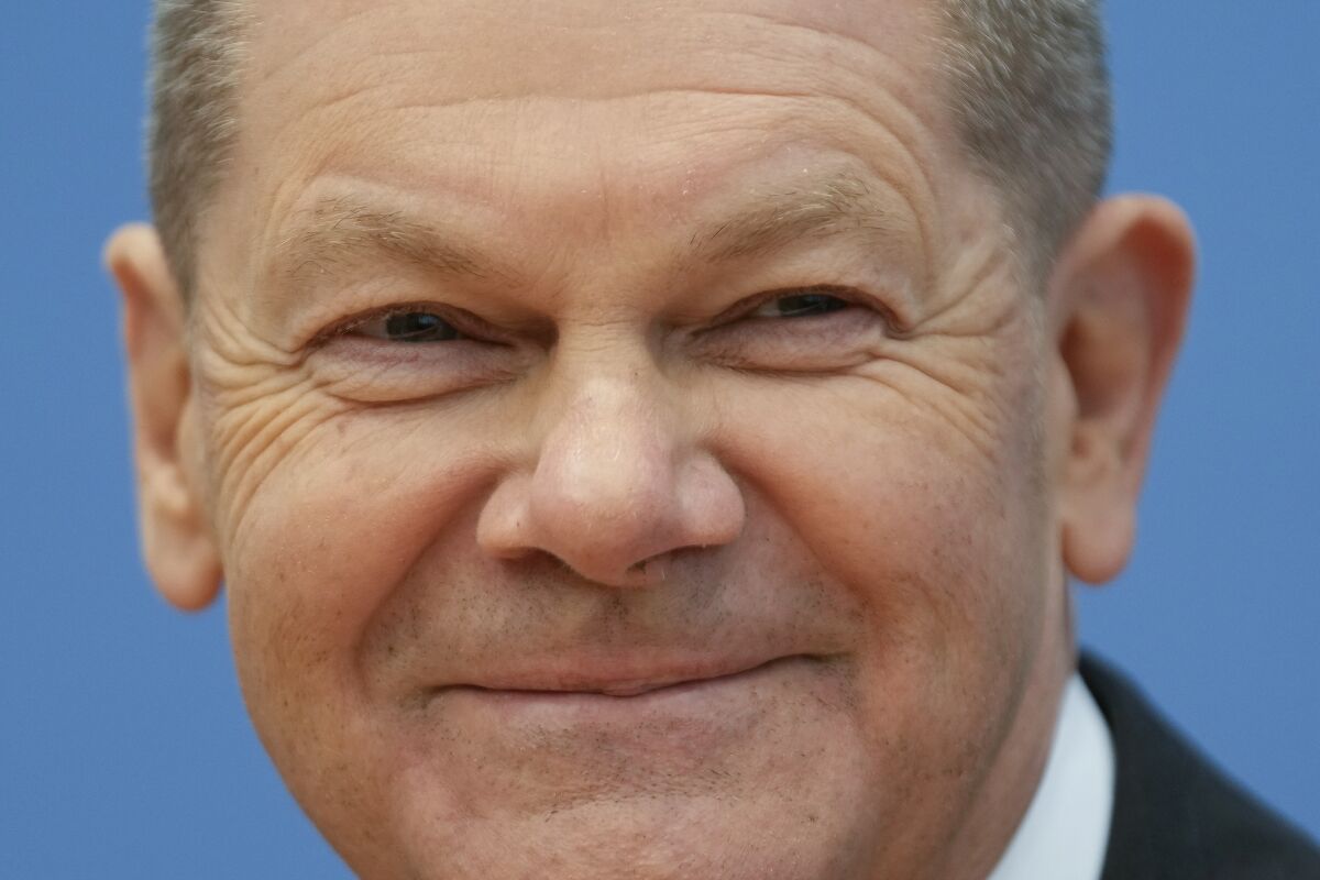 FILE - Designated German Chancellor Olaf Scholz smiles during a news conference after the signing of the coalition agreement with two other parties for new German government in Berlin, Germany, Tuesday, Dec. 7, 2021. The vice chancellor and finance minister in Merkel's government, Scholz rises to the top after propelling his center-left Social Democrats to an election win that appeared unlikely only months ago. (AP Photo/Markus Schreiber, File)