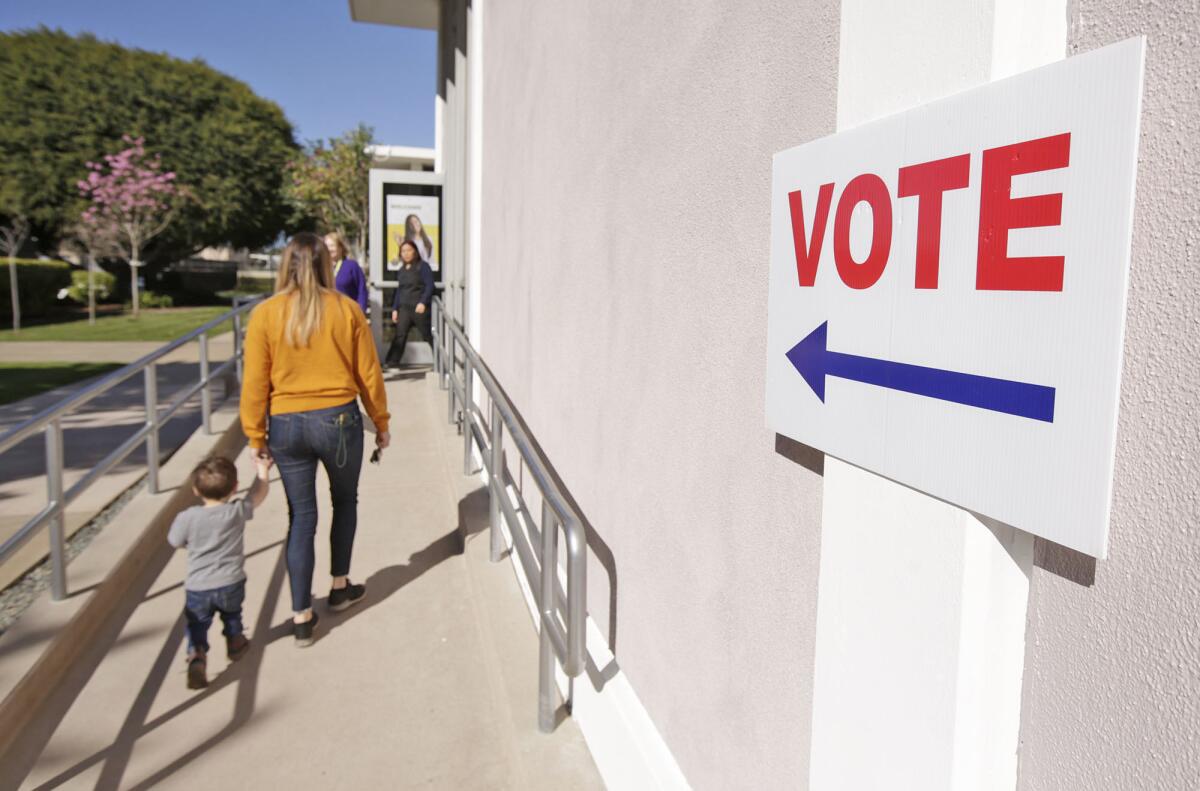 People walk to the vote center at Costa Mesa City Hall during the March 3 primary election.