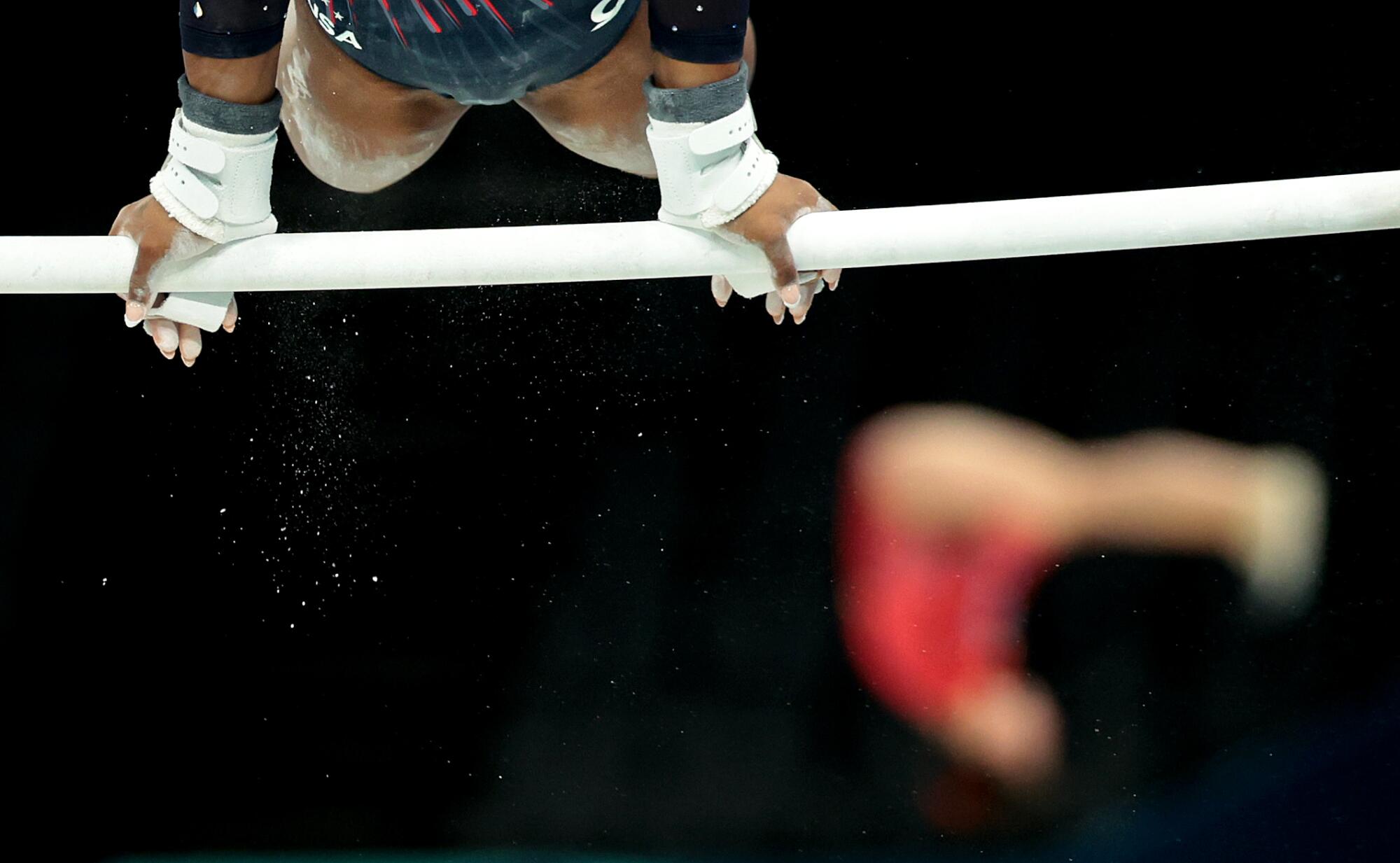 La gimnasta estadounidense Simone Biles se mueve sobre las barras asimétricas.