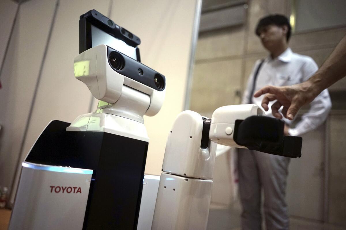 El nuevo robot HSR de Toyota en una muestra sobre enfermería y atención sanitaria en Yokohama, al sur de Tokio. El nuevo robot se desliza como R2-D2 y se centra en una tarea sencilla: recoger cosas.