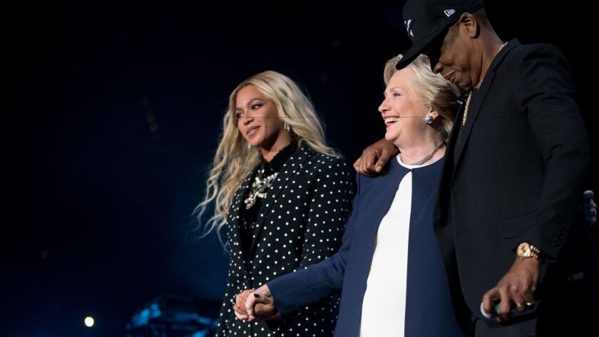Democratic presidential candidate Hillary Clinton, center, is welcomed to the stage by artists Jay Z, right, and Beyonce, left, during a free concert at at the Wolstein Center in Cleveland on Friday, Nov. 4.