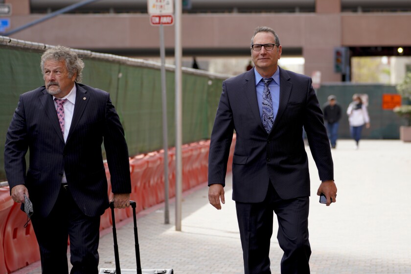 Former sheriff's Capt. Marco Garmo, right, leaves San Diego federal court with his lawyer, Kevin McDermott