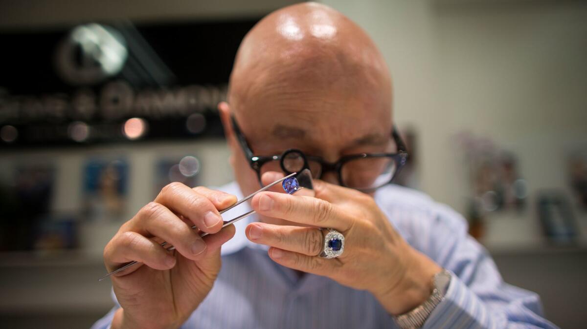 Jerry Young inspects a blue sapphire at Inta Gems & Diamonds. His store is the first owned by Cambodians in downtown L.A.'s Jewelry District.