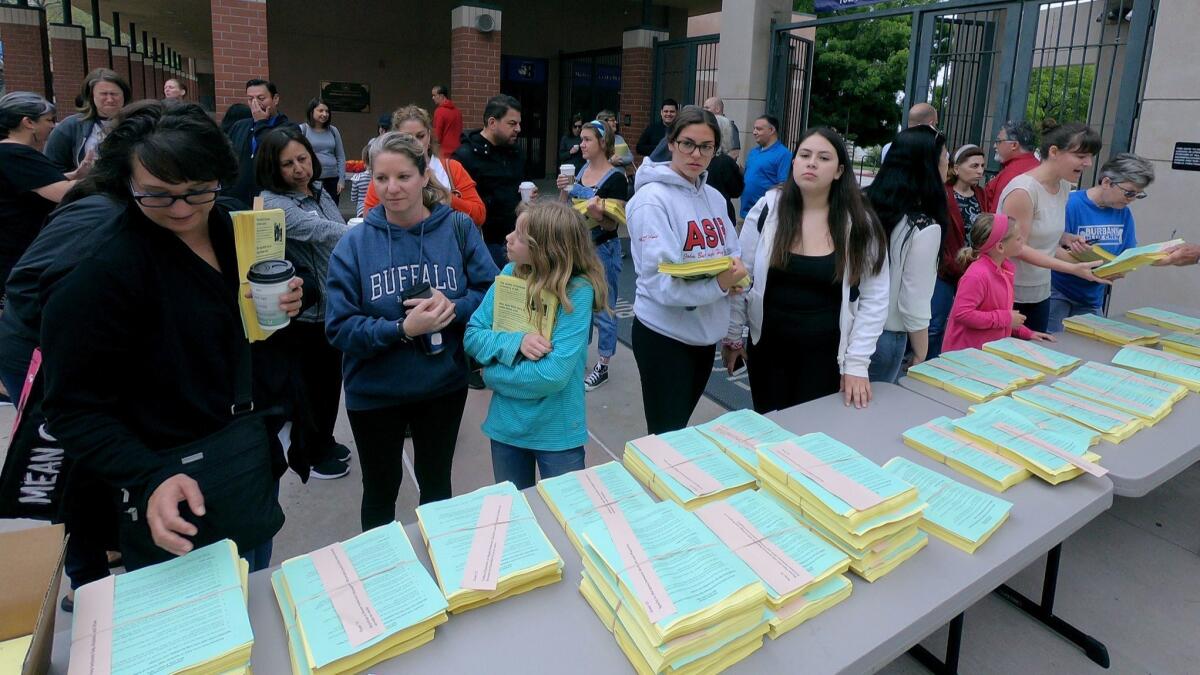 Parents, students and staff pick up bundles of informational flyers at Burbank High School to be passed out throughout city on Saturday. The flyers contained info about budgets cuts and the need for a parcel tax measure to raise funds for the school district.