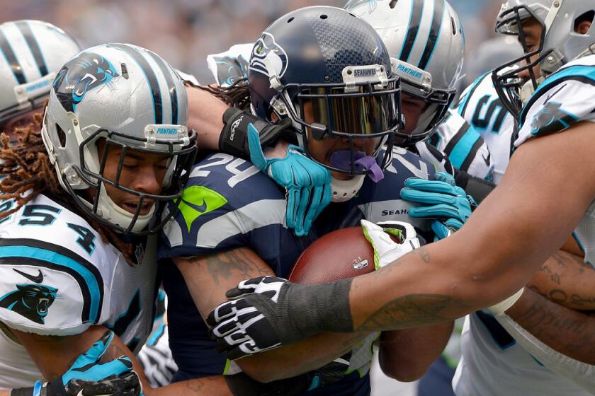 Seattle Seahawks' Marshawn Lynch (24) runs the ball against the Carolina Panthers in the first quarter during the NFC Divisional Playoff Game on Sunday.