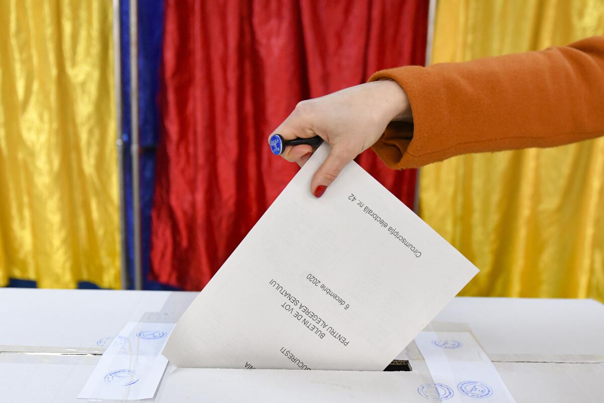 FILE - A woman casts her vote in Romania's legislative election, in Bucharest, Romania, Dec. 6, 2020. According to a study released Thursday, April 11, 2024, voters in 19 countries, including in three of the world’s largest democracies, are widely skeptical about whether their elections are free and fair, and many favor a strong, undemocratic leader. (AP Photo/Andreea Alexandru, File)