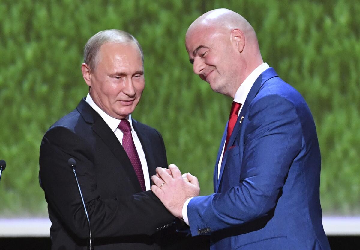 FIFA President Gianni Infantino and Russian President Vladimir Putin greet each other.