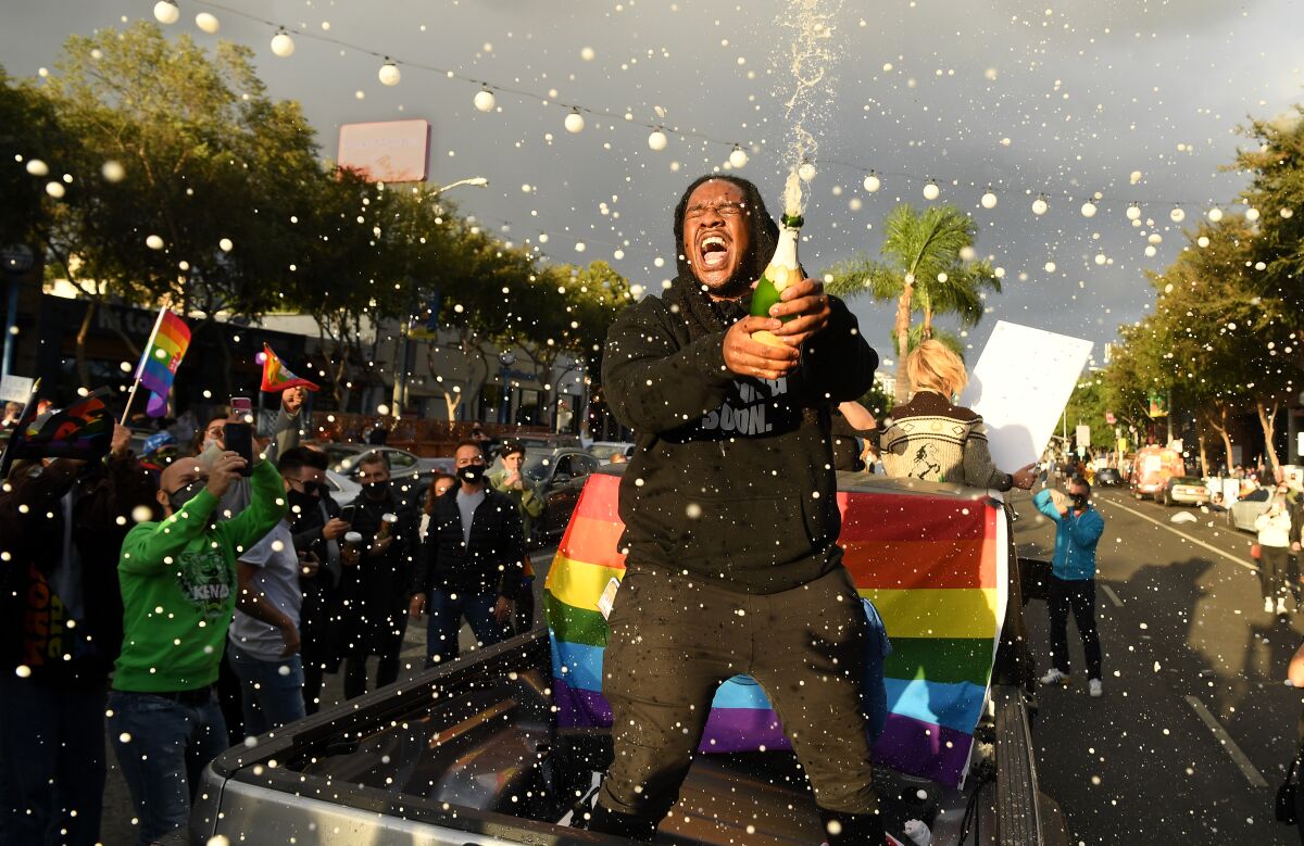 Revelers pop champagne bottles to celebrate Joe Biden's victory