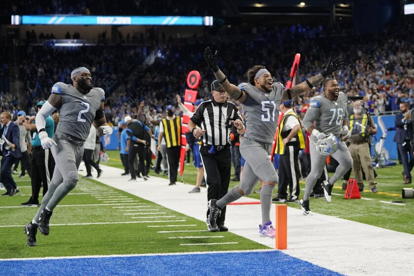 Detroit Lions linebacker Josh Woods (51) and linebacker Austin Bryant (2) run off the field after the second half of an NFL football game against the Minnesota Vikings, Sunday, Dec. 5, 2021, in Detroit. (AP Photo/Paul Sancya)