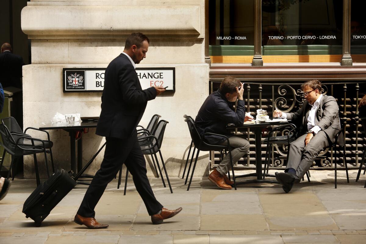 Near the Royal Exchange building in London, men take a break from work.