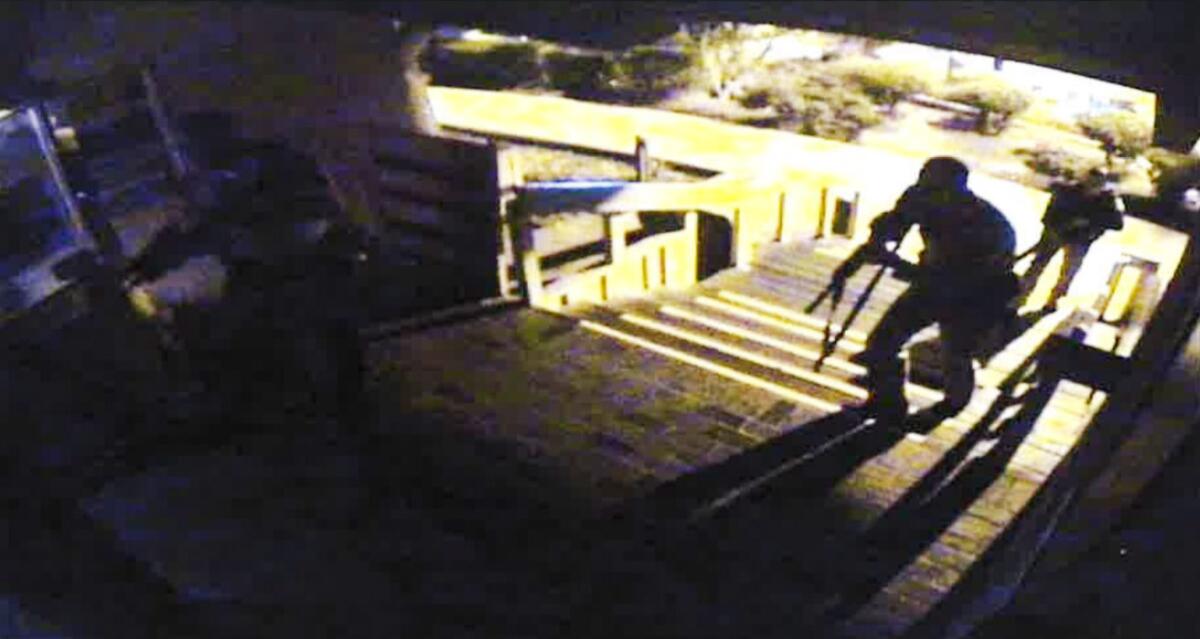A surveillance camera view of officers climbing the steps to enter Borderline Bar and Grill.