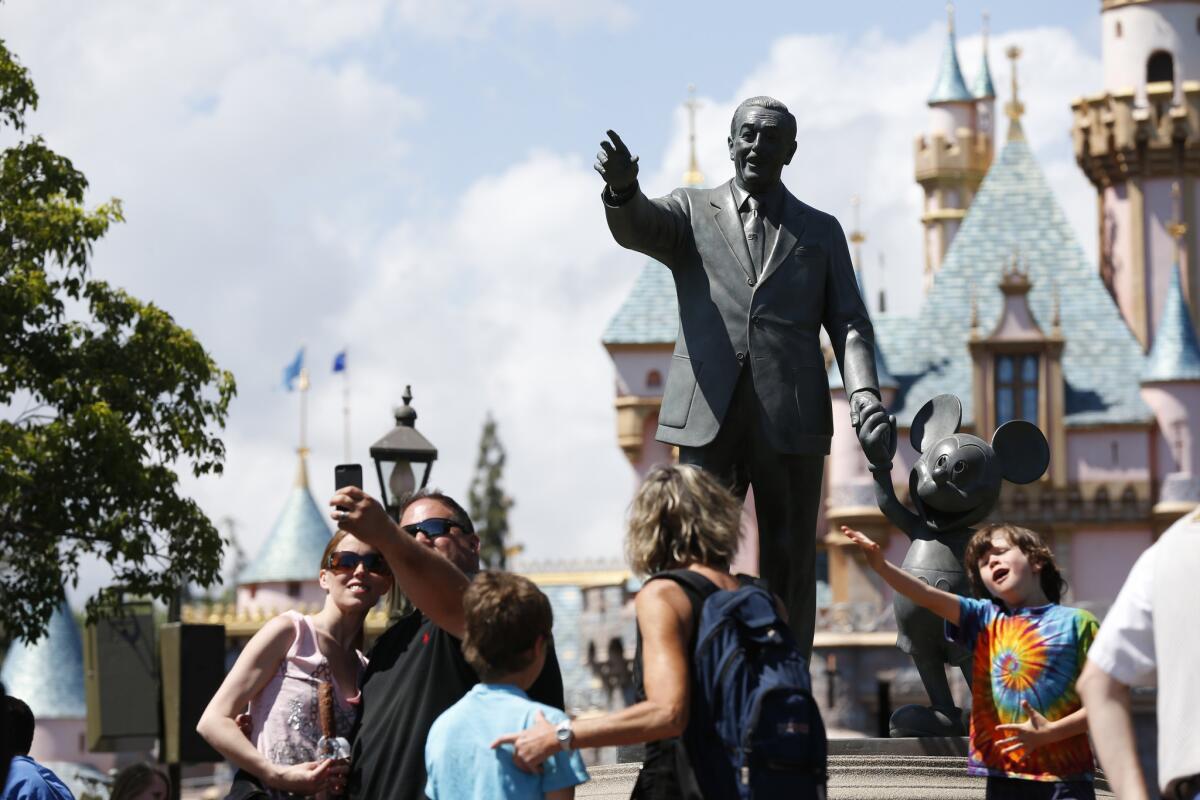 A statue of Walt Disney along Main Street in Disneyland. An O.C. man has been arrested on suspicion of selling two invalid tickets to the park.