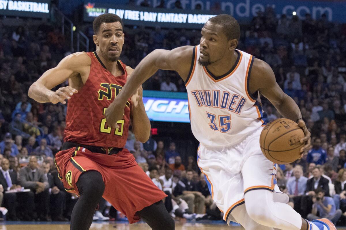 Thunder forward Kevin Durant (35) drives around Hawks defender Thabo Sefolosha (25) as he looks for a shot during the first half.