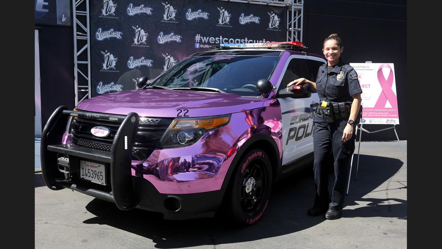 Burbank Police officer Angela Burrows stands next to a customized chrome pink police vehicle, for Breast Cancer Awareness month, at West Coast Customs, in Burbank on Thursday, Oct. 5, 2017.