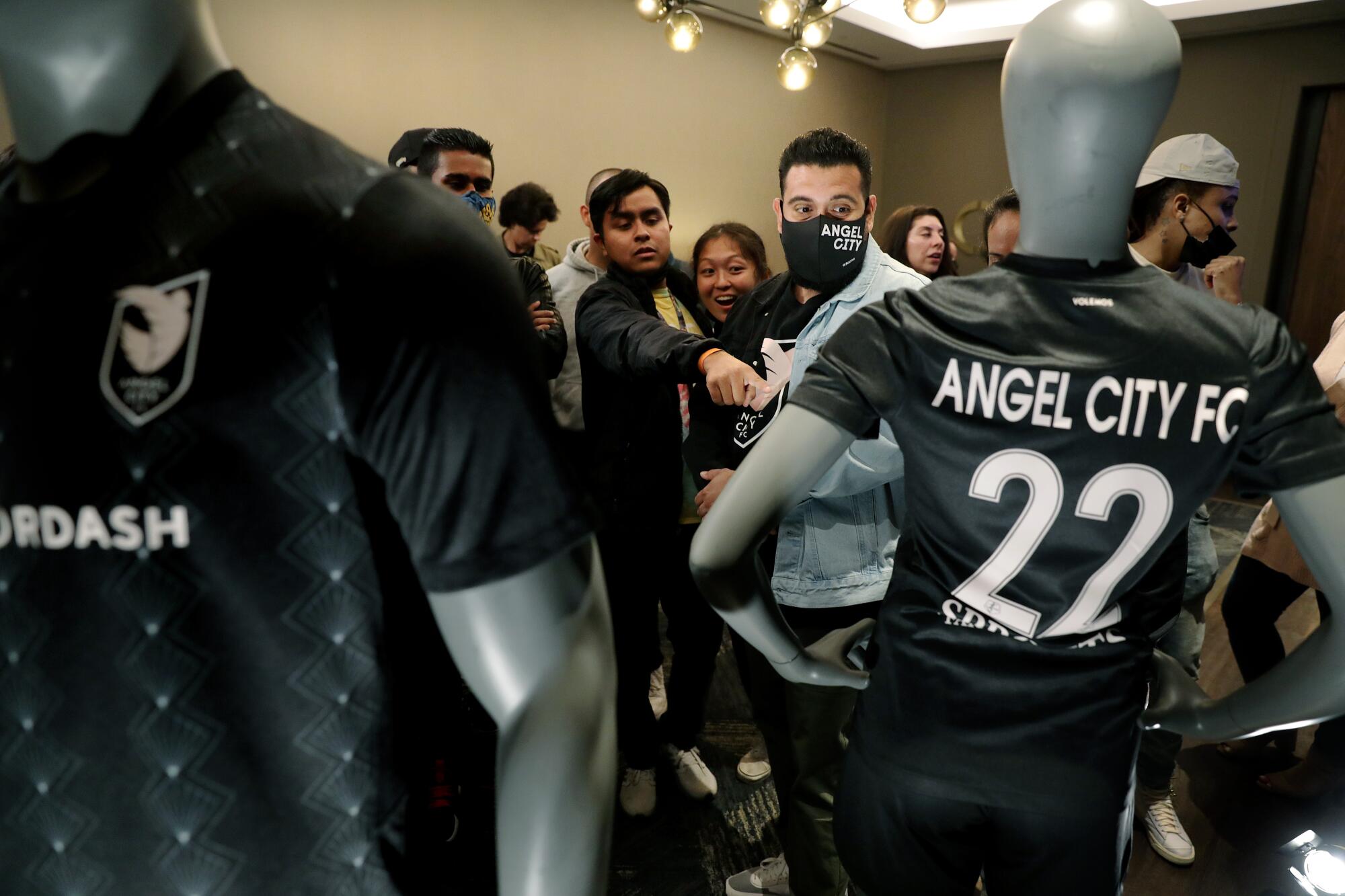 People point to the Angel City FC jersey at an unveiling event