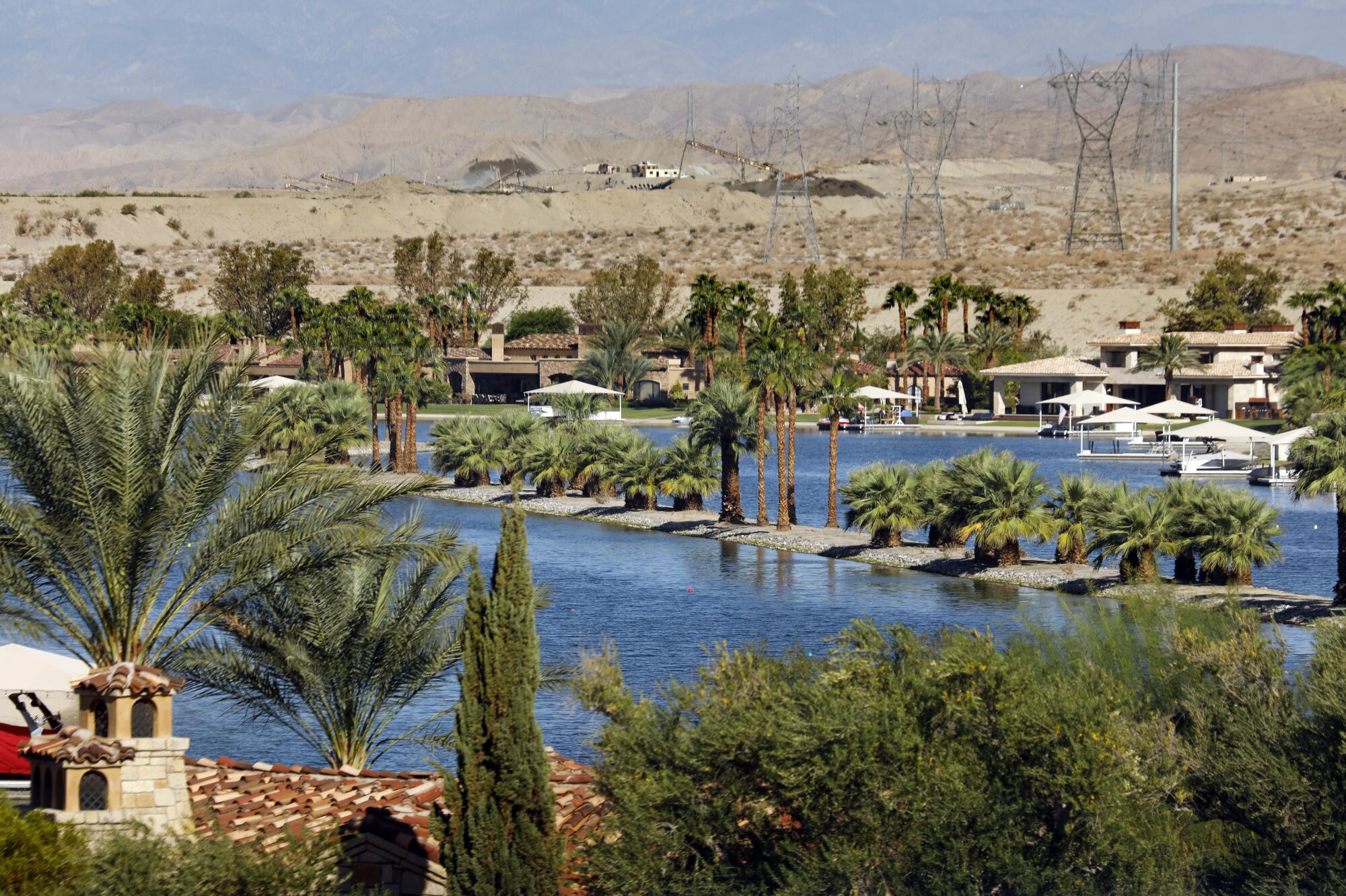 An upscale housing development with palm trees and an artificial lake