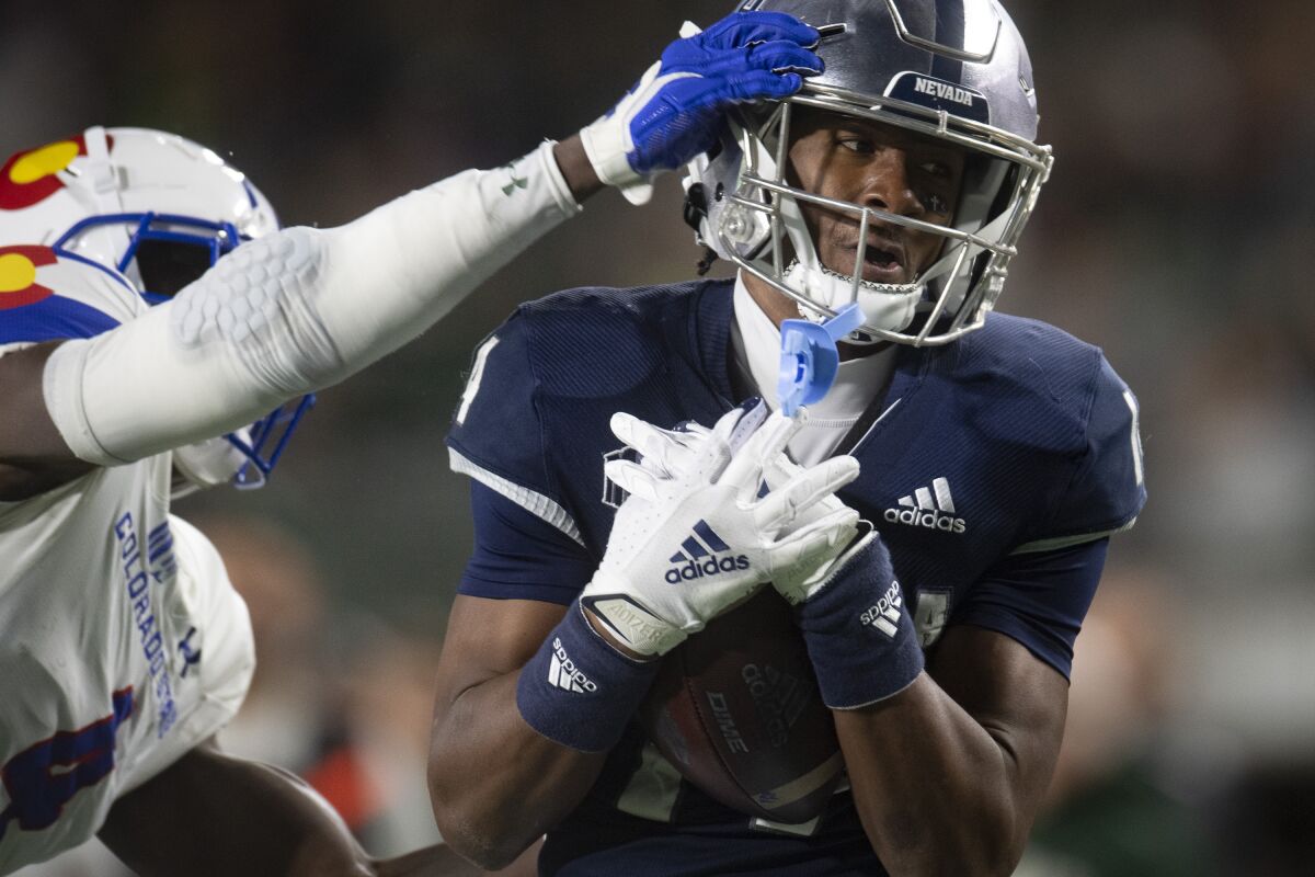 Nevada wide receiver Zach Lewis catches a pass next to Colorado State's Rashad Ajayi during an NCAA college football game Saturday, Nov. 27, 2021, in Fort Collins, Colorado. (Jon Austria/The Coloradoan via AP)