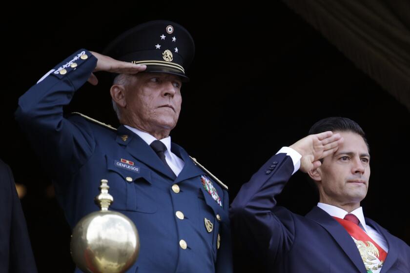 FILE - In this Sept. 16, 2016 file photo, Defense Secretary Gen. Salvador Cienfuegos, left, and Mexico's President Enrique Pena Nieto, salute during the annual Independence Day military parade in Mexico City's main square. The U.S. Justice Department is dropping its drug trafficking and money laundering against former Mexican defense secretary Gen. Salvador Cienfuegos, Attorney General William Barr said Tuesday, Nov. 17, 2020. (AP Photo/Rebecca Blackwell, File)