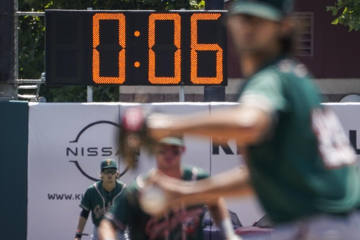 A pitch clock is deployed to restrict pitcher preparation times during a minor league baseball game.