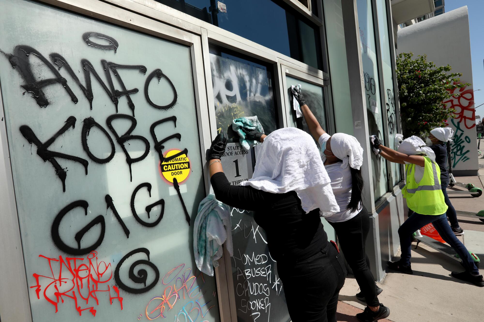 Interstate Restoration workers wash off graffiti on the Renaissance Tower apartment building on Olympic Boulevard.