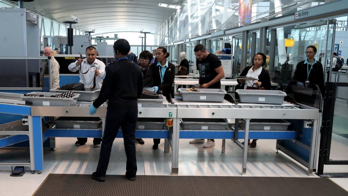 Passengers use a new checkpoint with automated screening lanes at John F. Kennedy International Airport in New York in May 2017. The lanes are meant to speed up screening times by allowing up to five passengers at a time to unload their carry-on bags, shoes and belts.