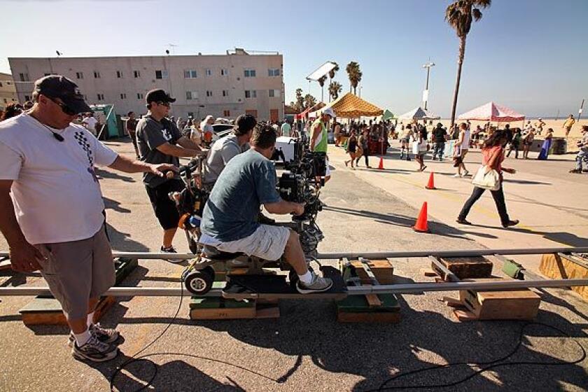B camera operator Fred Iannone moves on a camera dolly for a shot during shooting of "NCIS: Los Angeles."