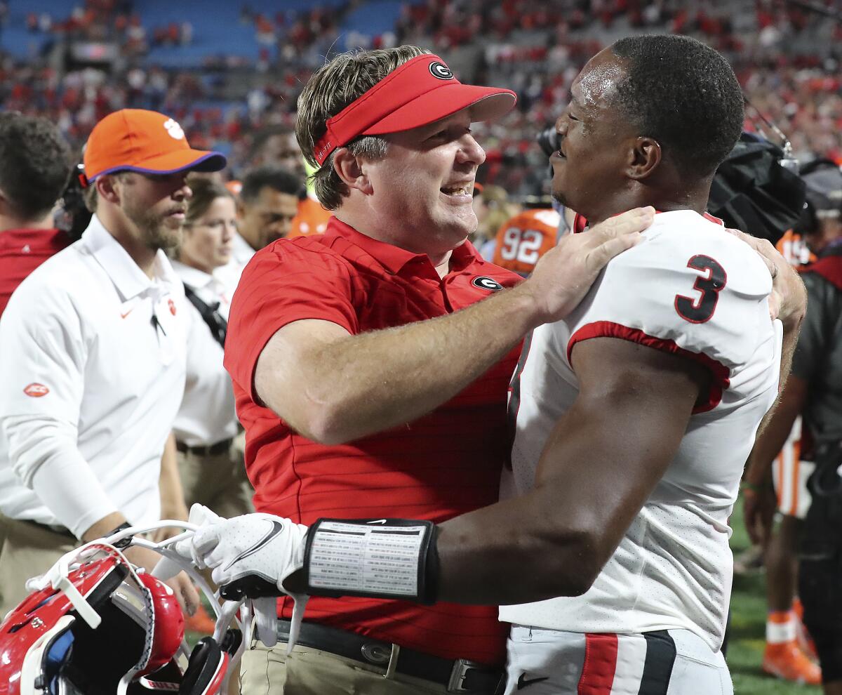 Georgia coach Kirby Smart and tailback Zamir White celebrate the team's win over Clemson in an NCAA college football game Saturday, Sept. 4, 2021, in Charlotte, N.C. (Curtis Compton/Atlanta Journal-Constitution via AP)
