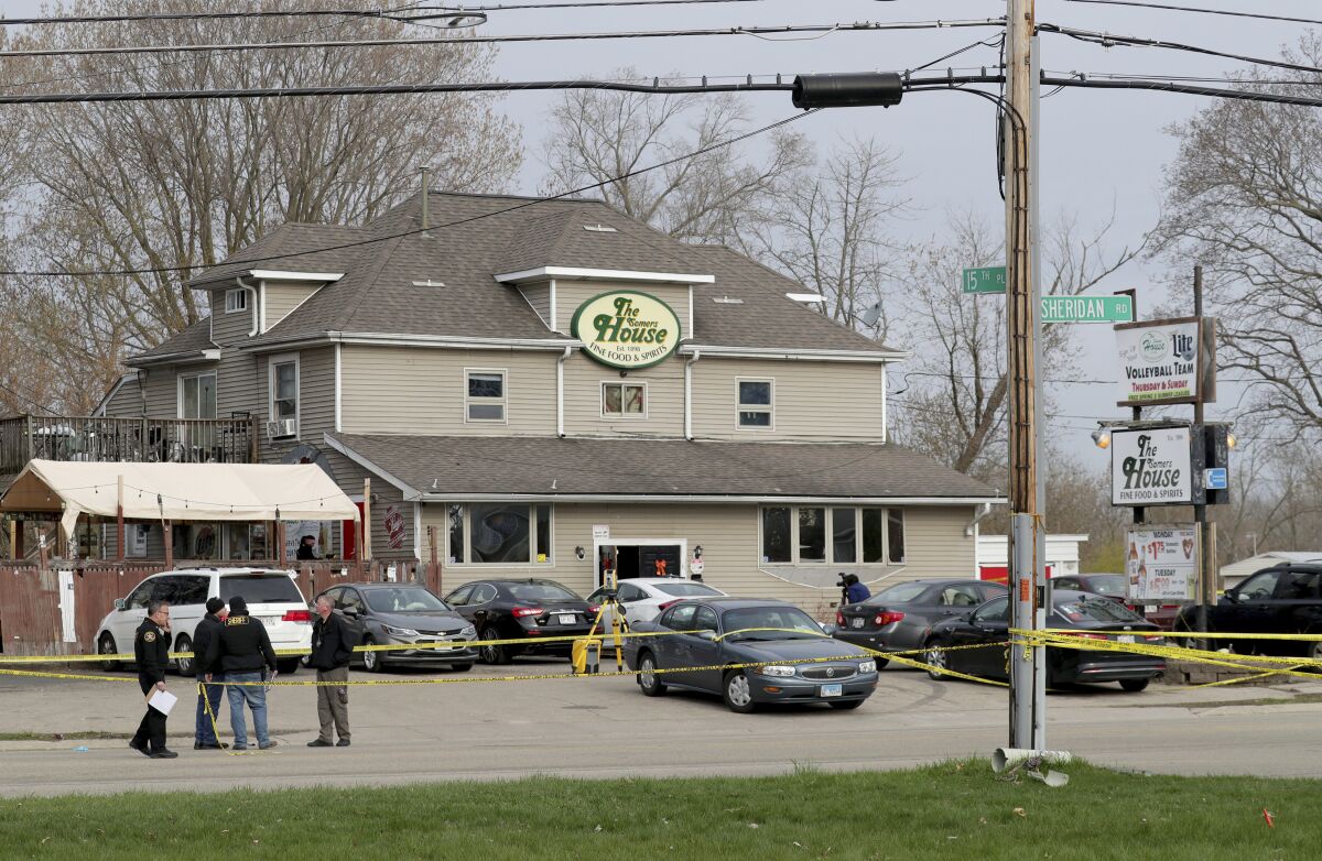 FILE - Officials investigate the scene of a deadly shooting at Somers House Tavern in Kenosha, Wis., April 18, 2021. A lawyer for Rakayo Vinson, charged with killing three people and wounding three others in the April shooting at the crowded bar in Wisconsin said Tuesday, Jan. 18, 2022, that his client wasn't the one looking for trouble. (Mike De Sisti/Milwaukee Journal-Sentinel via AP, File)