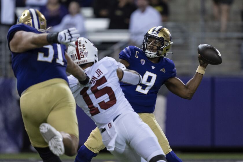 Washington quarterback Michael Penix Jr. attempts a pass while being pressured by Stanford defensive end Stephen Herron Jr. during the first half of an NCAA college football game Saturday, Sept. 24, 2022, in Seattle. (AP Photo/Stephen Brashear)