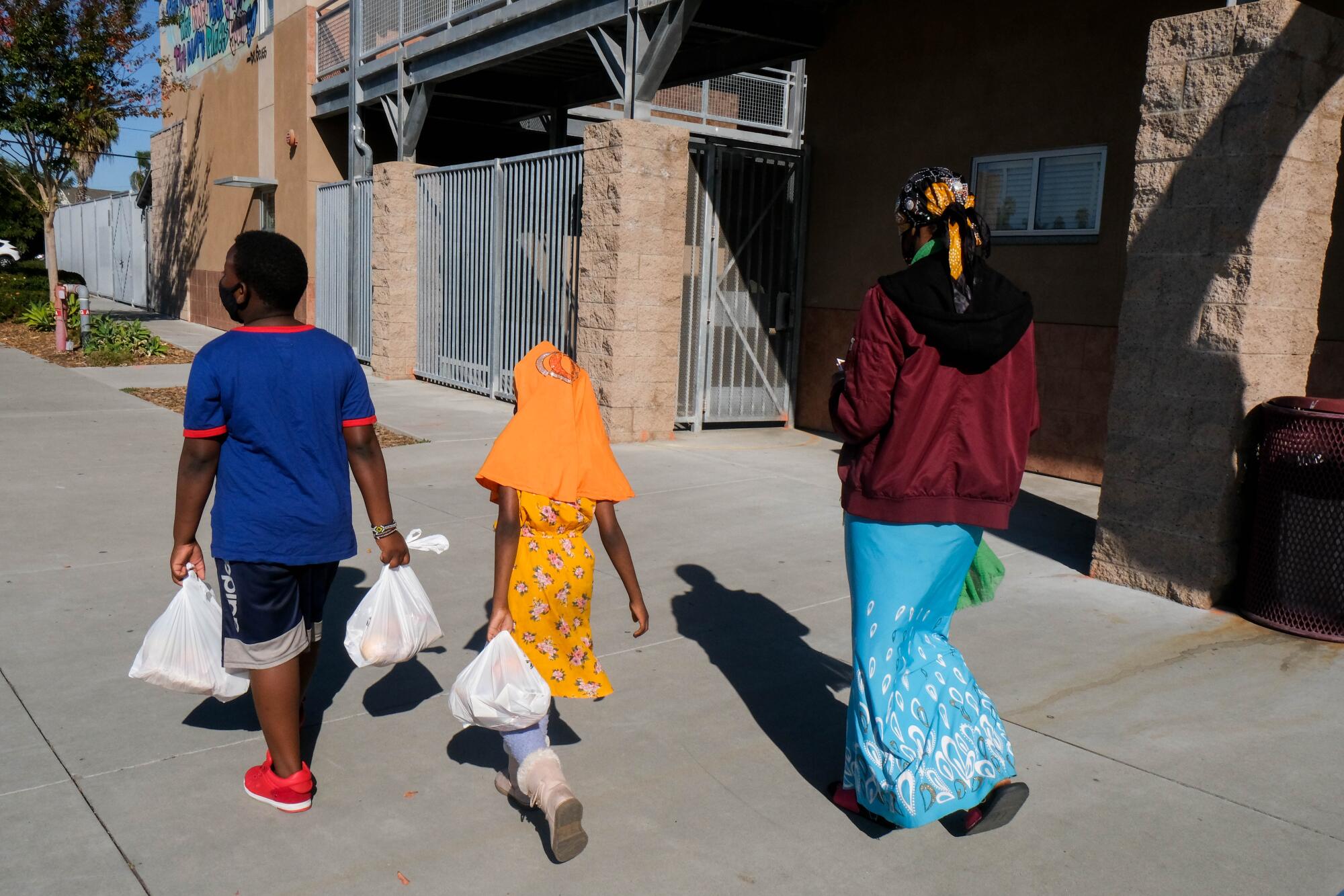 Musa, Osman, 10, and Sadiya, 7, walk to a San Diego Unified School District campus down the street